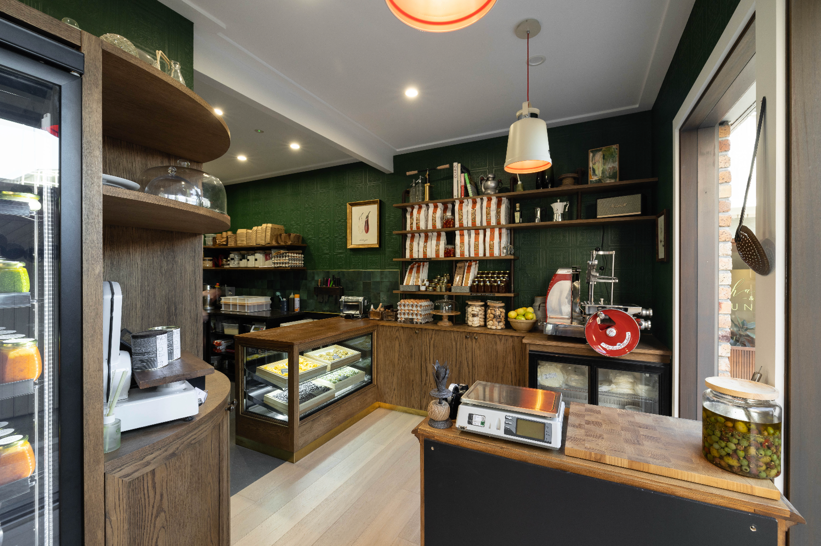 Modern kitchen or bakery interior with wooden counters and shelves.