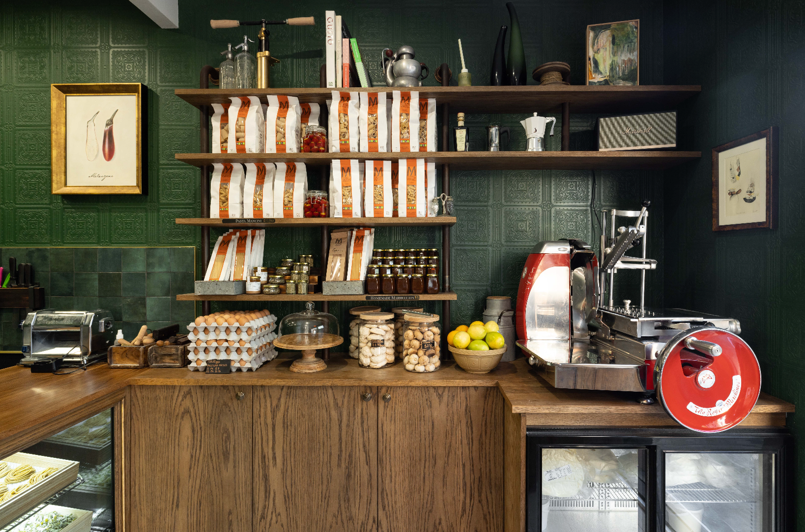 Coffee shop interior with shelves stocked with coffee bags and a counter with coffee-making equipment.
